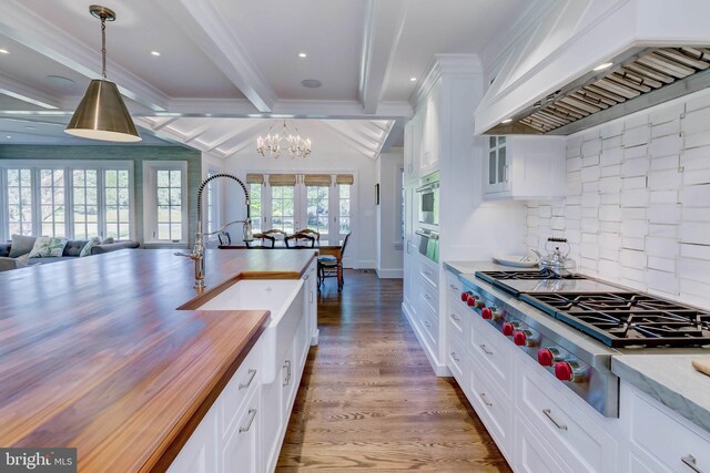 13401 Longnecker Rd, Reisterstown, MD 21136 - kitchen featuring stainless steel gas cooktop, butcher block counters, wood finished floors, premium range hood, and beamed ceiling