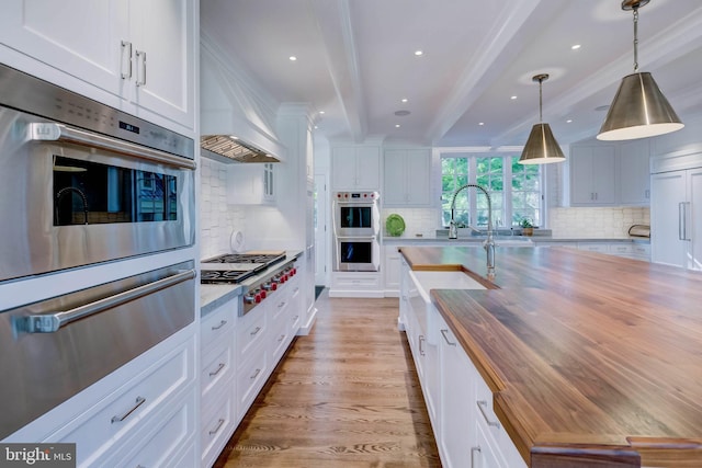 13401 Longnecker Rd, Reisterstown, MD 21136 - kitchen with beam ceiling, light wood finished floors, appliances with stainless steel finishes, a sink, and wood counters