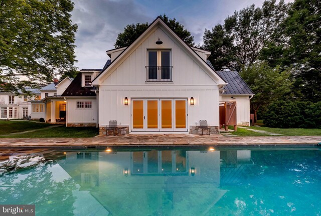 13401 Longnecker Rd, Reisterstown, MD 21136 - rear view of house with metal roof, board and batten siding, an outdoor pool, a standing seam roof, and a patio area