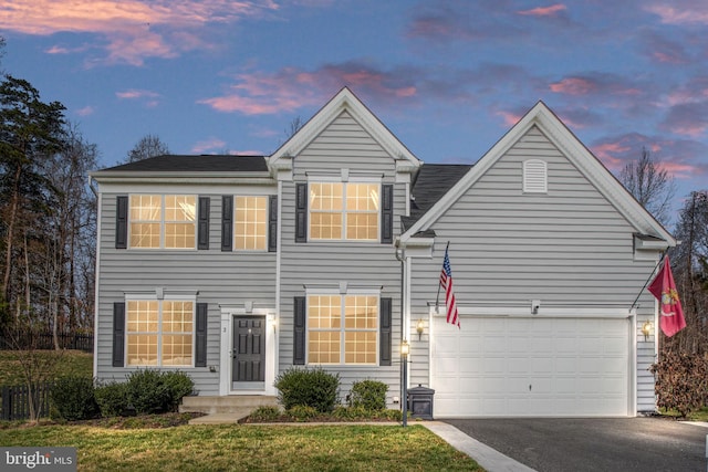 traditional-style home with aphalt driveway and a garage