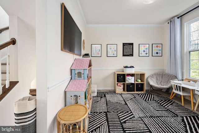 recreation room featuring plenty of natural light, crown molding, and baseboards