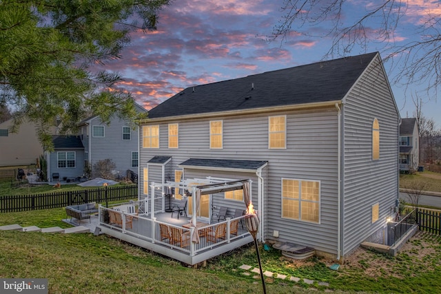 back of property featuring a deck, a lawn, and a fenced backyard