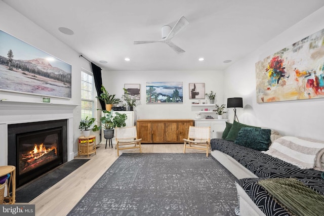 sitting room featuring ceiling fan, a fireplace with flush hearth, wood finished floors, and recessed lighting