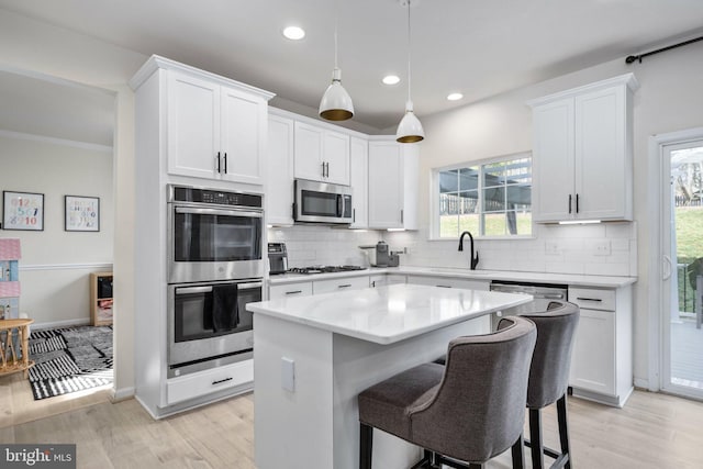 kitchen with a sink, tasteful backsplash, a kitchen island, and stainless steel appliances