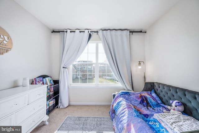 bedroom with baseboards and light carpet