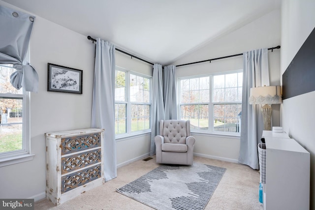 sitting room with baseboards, lofted ceiling, light carpet, and visible vents