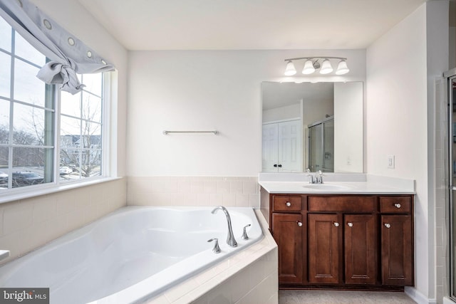 full bathroom with a bath, a shower stall, and vanity