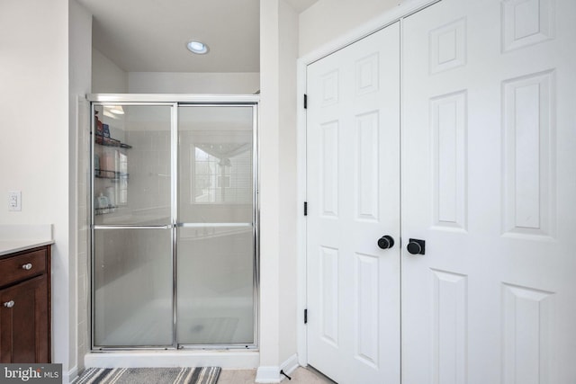 full bathroom with vanity, baseboards, and a stall shower