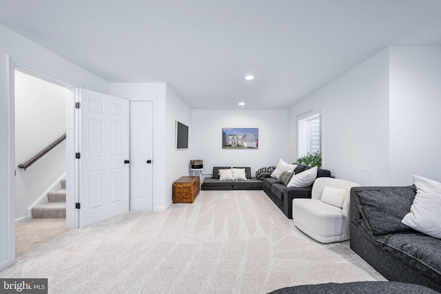 carpeted living room with stairs and recessed lighting