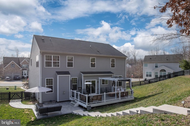 back of property with a fenced backyard, a deck, a patio area, and a yard