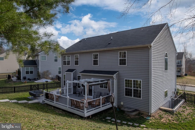 rear view of house featuring a yard, a wooden deck, and a fenced backyard