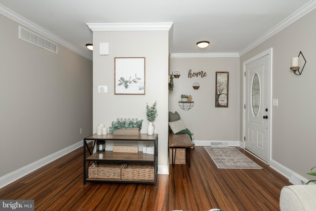 foyer entrance featuring ornamental molding, visible vents, and wood finished floors