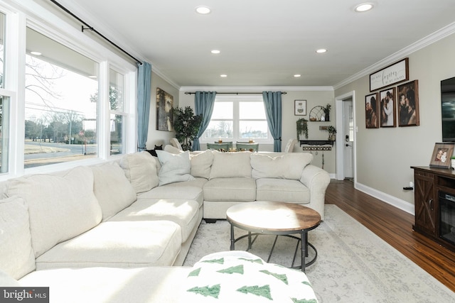 living room featuring baseboards, ornamental molding, wood finished floors, and recessed lighting