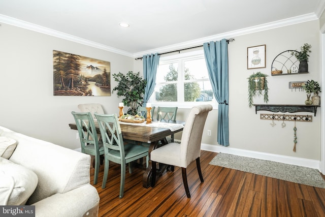 dining space with baseboards, ornamental molding, and wood finished floors