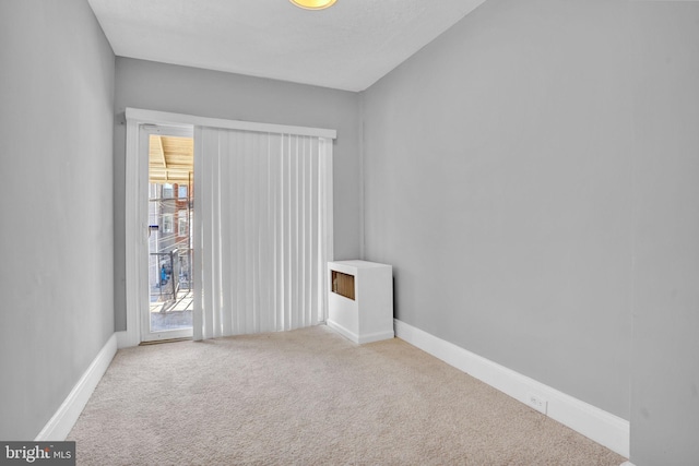 carpeted spare room with baseboards