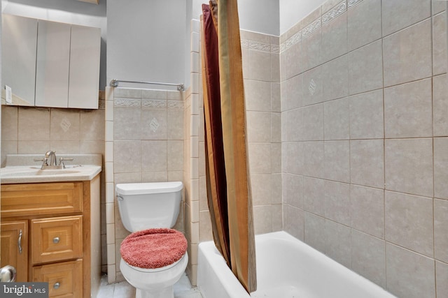 full bath with toilet, shower / bath combo with shower curtain, vanity, and tile walls