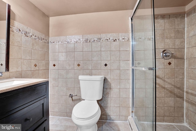 full bath with toilet, a shower stall, and tile walls