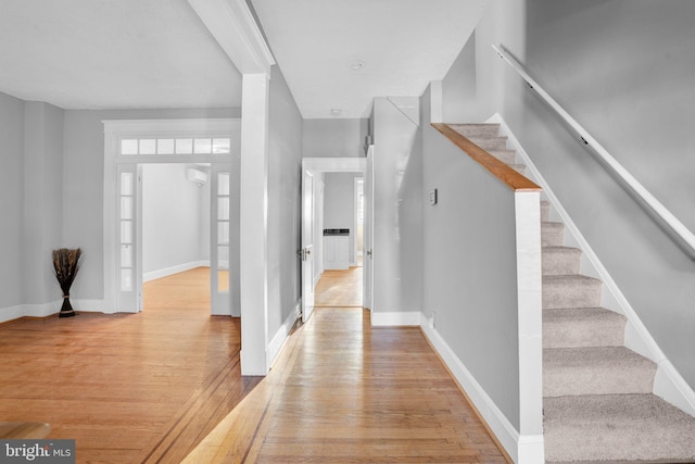 entryway featuring stairs, light wood-type flooring, and baseboards