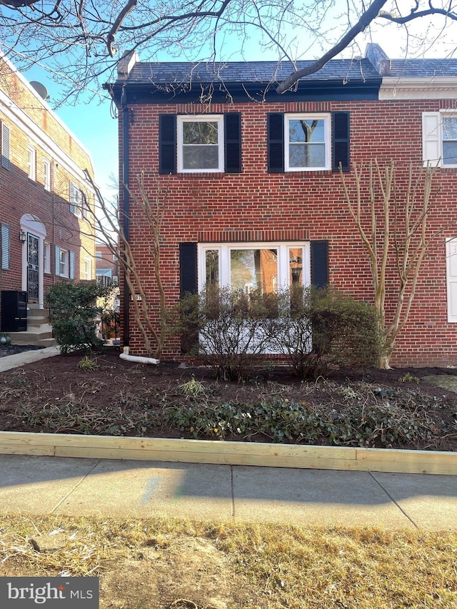 view of side of home featuring brick siding and central AC unit