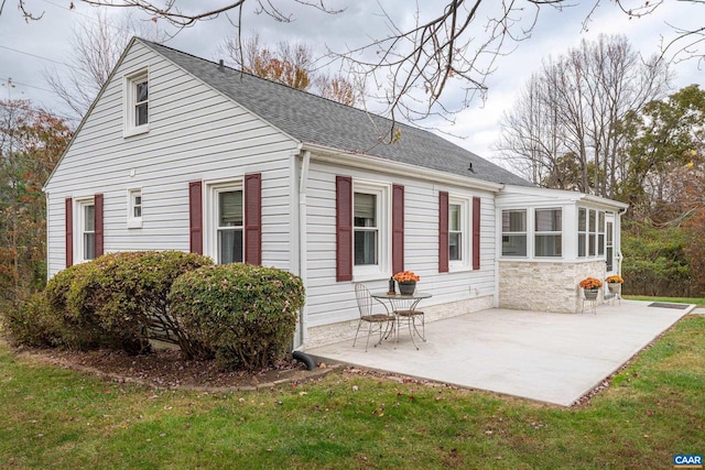 back of house with a lawn and a patio area