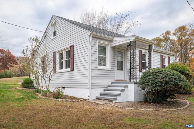 bungalow-style home featuring crawl space, roof with shingles, and a front lawn