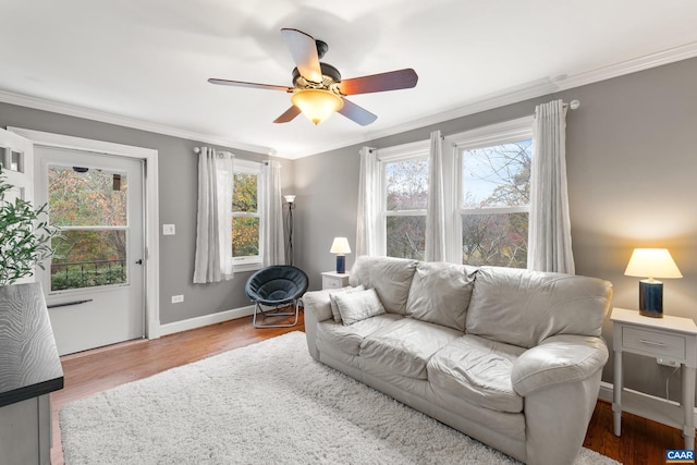 living room with ornamental molding, plenty of natural light, baseboards, and wood finished floors