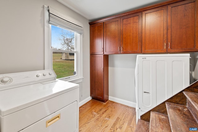 laundry room with washer / dryer, baseboards, light wood finished floors, and cabinet space