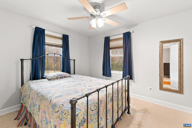 carpeted bedroom with ceiling fan and baseboards