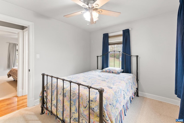 carpeted bedroom with ceiling fan and baseboards