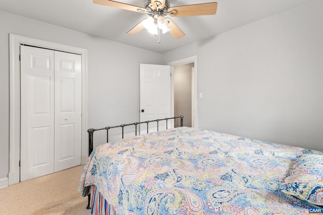 bedroom with light carpet, ceiling fan, and a closet