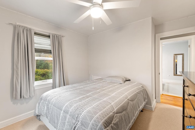 carpeted bedroom with ceiling fan and baseboards