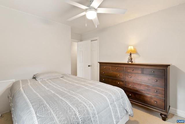 carpeted bedroom with a closet, baseboards, and a ceiling fan