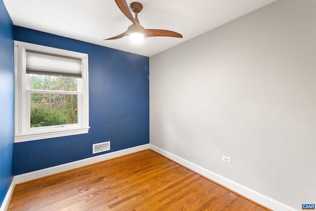 empty room with visible vents, ceiling fan, baseboards, and wood finished floors