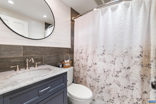 full bathroom featuring toilet, curtained shower, wooden walls, and vanity