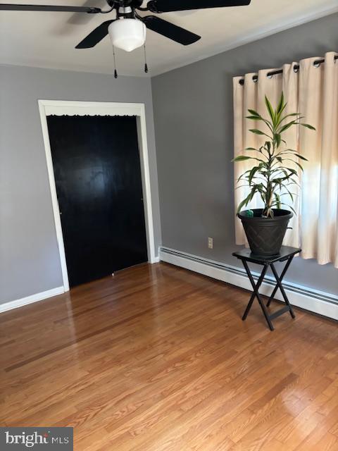 entrance foyer featuring light wood finished floors, ceiling fan, baseboards, and baseboard heating