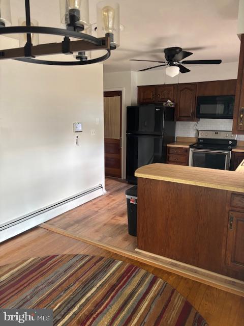 kitchen featuring dark brown cabinets, ceiling fan, black appliances, and wood finished floors