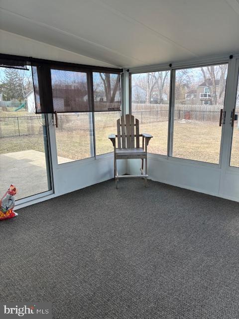 unfurnished sunroom featuring lofted ceiling