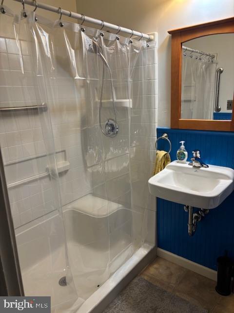 full bath featuring a stall shower, a sink, and tile patterned floors