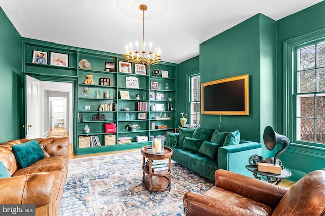 sitting room with a chandelier and wood finished floors