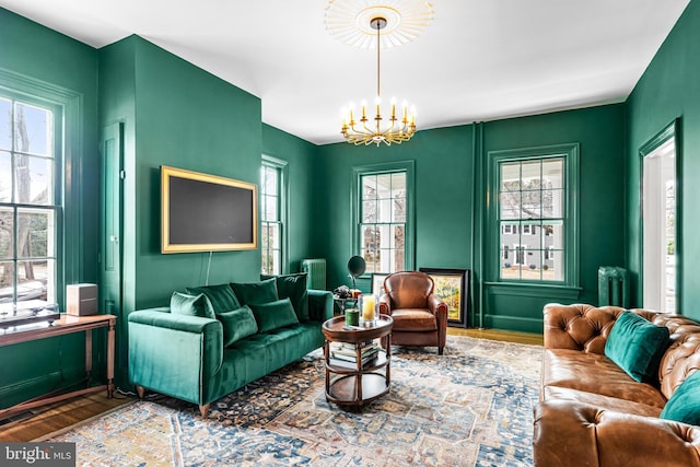 living area featuring a chandelier, radiator heating unit, and wood finished floors