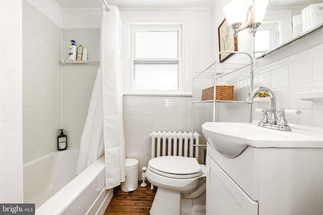 full bathroom featuring a healthy amount of sunlight, tile walls, toilet, and wood finished floors