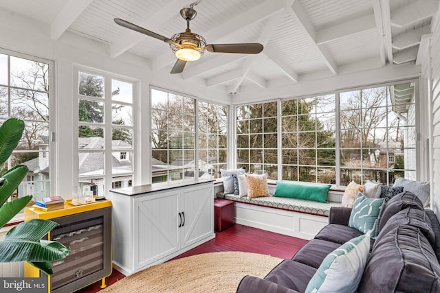 sunroom / solarium with a healthy amount of sunlight, ceiling fan, and beam ceiling