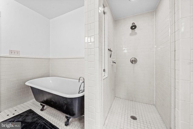 full bathroom with a tile shower, wainscoting, a freestanding tub, and tile walls