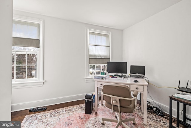 office space featuring plenty of natural light, baseboards, and wood finished floors