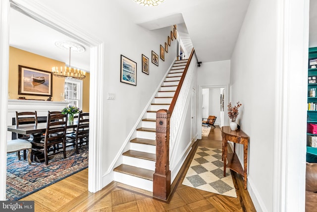 stairs with a notable chandelier and baseboards