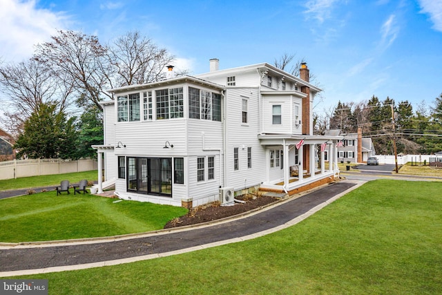 back of house featuring a yard, a chimney, fence, and ac unit