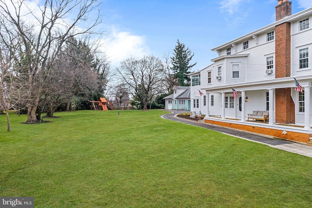 view of yard featuring a porch and a playground