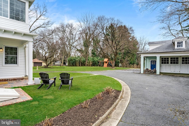 view of yard featuring driveway and a playground