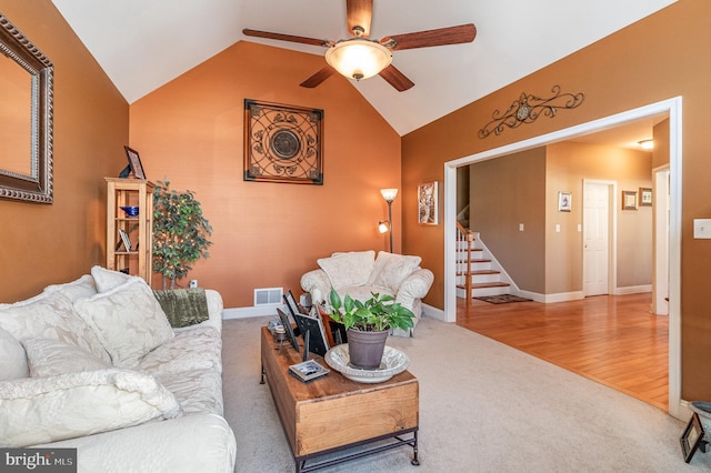 carpeted living room with visible vents, ceiling fan, baseboards, stairs, and lofted ceiling