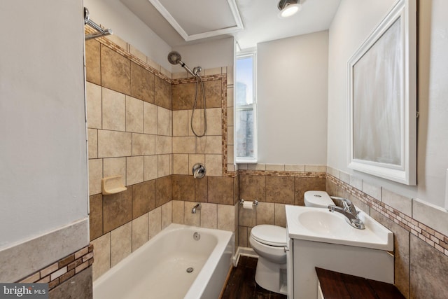 1306 E St NE, Washington, DC 20002 - bathroom with toilet, tile walls, shower / tub combination, vanity, and wainscoting